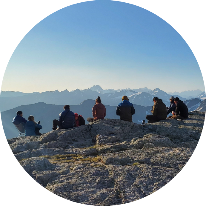 Veterans standing together on top of a summit looking across mountain tops.